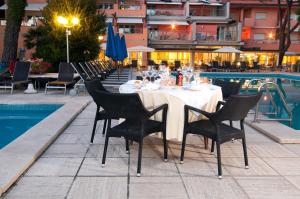 a dining area with tables and chairs and umbrellas at Versilia Palace Hotel in Marina di Pietrasanta
