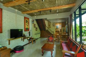 a living room with a couch and a tv at The Corner's unique house in Chiang Mai