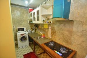 una pequeña cocina con fregadero y lavadora en The Corner's unique house en Chiang Mai