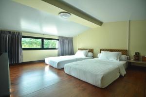 twee bedden in een hotelkamer met bij The Corner's unique house in Chiang Mai