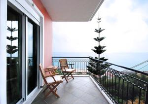Un balcón con sillas y vistas al océano. en Villa Sunset, en Paralia Vrachou