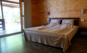 
a bed in a room with a wooden floor at MamaGoa Resort in Mandrem
