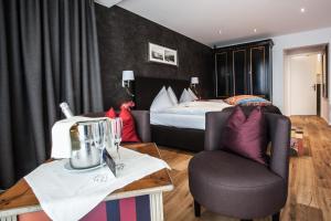 um quarto de hotel com uma cama e uma cadeira em Hotel Riviera Loft em Weggis
