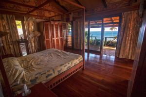 Maravu Taveuni Lodge في ماتي: غرفة نوم مع سرير وإطلالة على المحيط