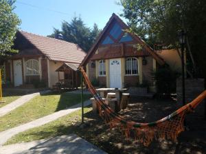 una casa con una hamaca delante en Cabañas el Fantasio en Villa Carlos Paz