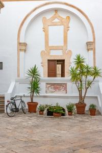 un vélo garé devant un immeuble avec des plantes dans l'établissement Palazzo Cariddi, à Nardò