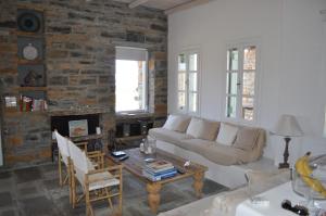 a living room with a couch and a brick wall at The Hill Top House in Kea in Ioulis