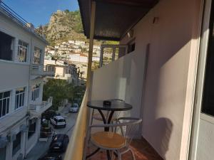 Un balcón con una mesa y dos taburetes. en Apartment Donend, en Berat