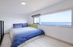 Postel nebo postele na pokoji v ubytování Jeju Turning point Pension