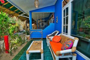 a porch with a couch and a table on a house at Rumah Kundun in Gili Trawangan