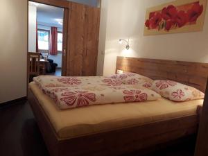 ein Schlafzimmer mit einem Bett mit Kissen darauf in der Unterkunft Ferienwohnung Eiterer in Kauns