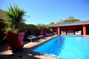 a swimming pool on a patio with chairs at La Villa Léa in Uzès