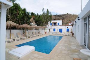 einen Pool mit Stühlen und Sonnenschirmen in einem Resort in der Unterkunft Lithos Studios in Oroklini
