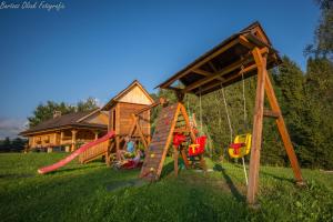 een speeltuin met een speelset en een huis bij Tylicki Zdrój in Tylicz