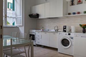 una cucina con lavatrice e tavolo di Marbel - Casa vacanze a Roma