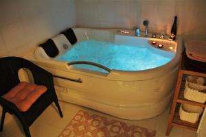 een badkamer met een bad gevuld met blauw water bij Apartmány Hutisko 769 in Hutisko