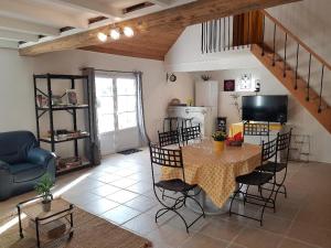 a living room with a table and chairs and a kitchen at Le Grand Coudreau in Nazelles