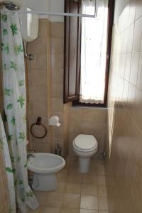 a bathroom with a toilet and a sink and a window at La casetta in piazza in Porto Santo Stefano