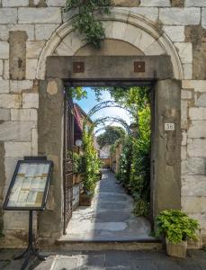 uma entrada para um edifício com um arco com plantas em Hotel Amalfitana em Pisa