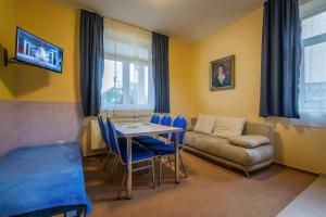 sala de estar con mesa, sillas y sofá en Miramonti Apartmány, en Vysoke Tatry - Horny Smokovec