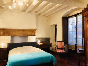 a bedroom with a bed and a desk and a window at Le Gite de la Muraille in Le Mans