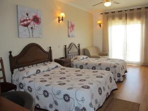 a bedroom with two beds with white and black sheets at Flor Do Douro in Miranda do Douro