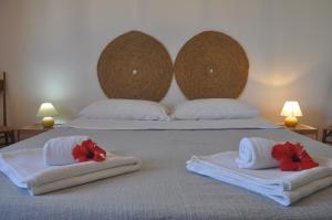 a bed with towels and flowers on top of it at Apartments Scopello Inside in Scopello