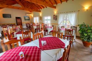 un restaurante con mesas y sillas rojas y blancas en Apart Hotel Las Palmeras en Villa General Belgrano