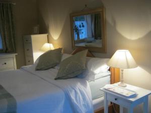 um quarto com uma cama e uma mesa com um candeeiro em The Moats - Ledbury em Ledbury