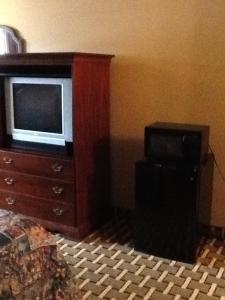 ein Wohnzimmer mit einem TV auf einer Kommode in der Unterkunft Caronoda Motel in Central City