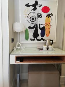 een bureau met een wastafel en een schilderij aan de muur bij Just Inn Hotel in Istanbul