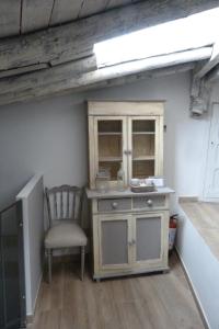 a kitchen with a chair and a cabinet and a window at Casa de Tintas in Cuenca