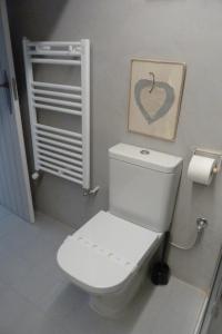 a bathroom with a white toilet and a picture of a heart at Casa de Tintas in Cuenca