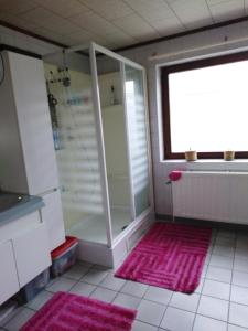 y baño con ducha y alfombra rosa. en Chez YOYO en Stavelot