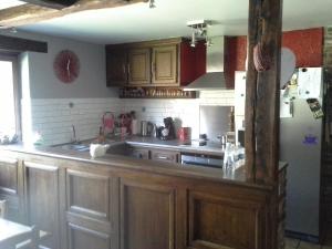 una cucina con armadi in legno e frigorifero di Chez YOYO a Stavelot