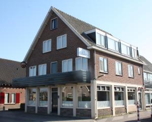 een groot bakstenen gebouw met een bord erop bij Hotel 't Meertje in Vinkeveen