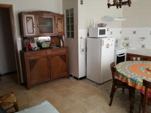 福爾米蓋雷的住宿－Résidence Llapasset，厨房配有桌子和白色冰箱。