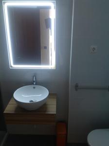 un bagno con un lavandino bianco e uno specchio di Beach apartment... T1 with swimming pool (summer) a Costa da Caparica