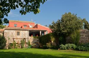 an old stone house with a red roof at Turisme Rural Mas Masaller in Cruïlles