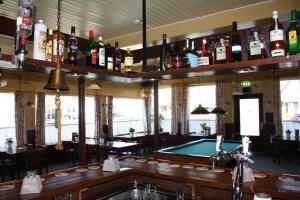 a bar with a pool table and lots of bottles at Hotel 't Meertje in Vinkeveen