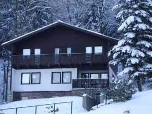 a large house with a balcony in the snow at Chalet in Dolní Brusnice near Ski Lift in Bílá Třemešná