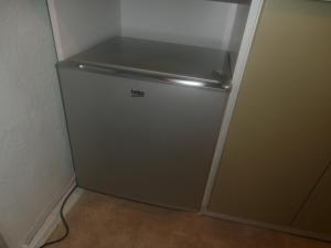 a silver refrigerator in a corner of a room at Central Daugavpils Apartment in Daugavpils