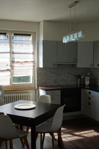 a kitchen with a black table and chairs and a table and a table at Maujobia 31 in Neuchâtel