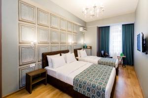 a hotel room with two beds and a chandelier at Hotel Diamond in Tbilisi City