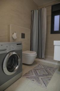 a bathroom with a washing machine and a toilet at Ramallah Modern Apartment in Ramallah