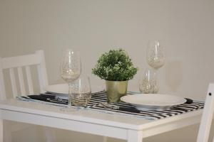 une table avec des assiettes et des verres et une plante en pot dans l'établissement Ramallah Modern Apartment, à Ramallah