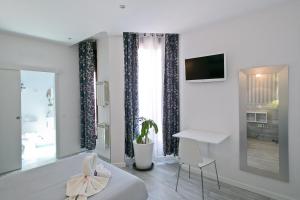 a bedroom with a bed and a desk and a television at Hostal Main Street Madrid in Madrid
