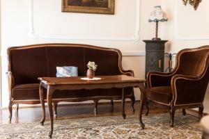 sala de estar con sofá, mesa y 2 sillas en Kikelet Panzio, en Dunakeszi