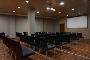 een vergaderzaal met zwarte stoelen en een scherm bij Exe Moncloa in Madrid