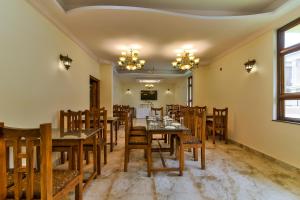 a dining room with wooden tables and chairs at Sonikas Leisure in Candolim